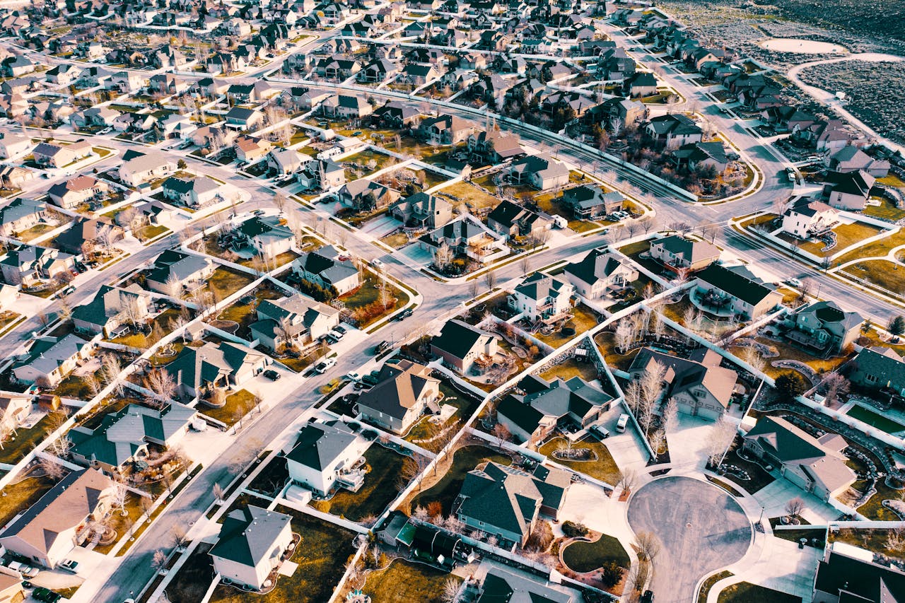 Vista aérea de un barrio residencial con calles curvilíneas y casas unifamiliares.