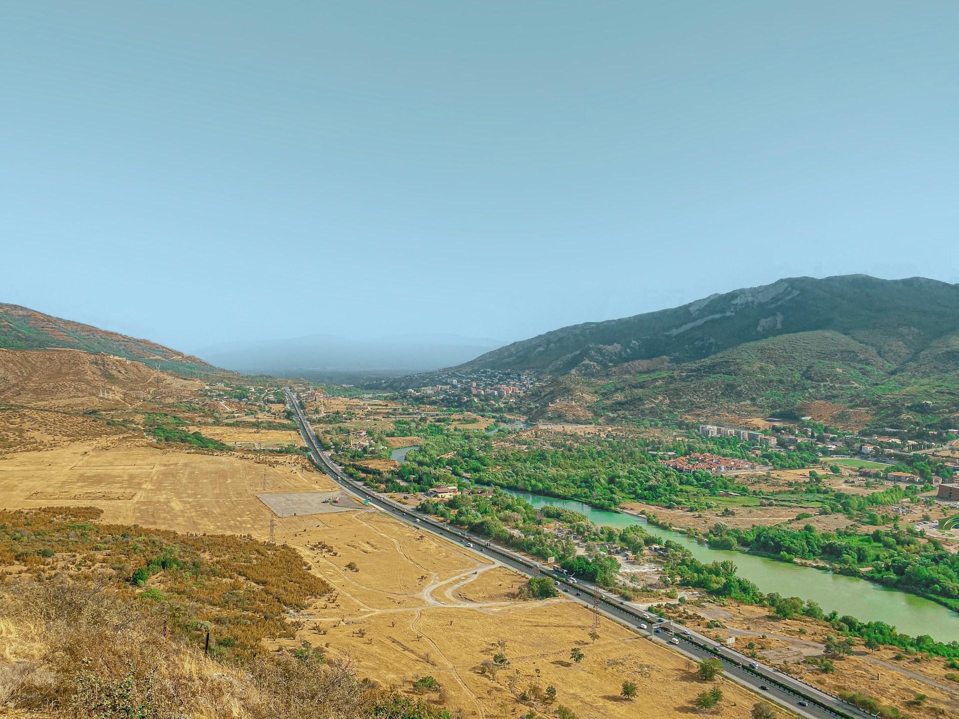 Montañas y río bajo cielo despejado.